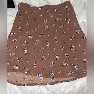 Brown skirt, blue floral pattern, and slightly ruffled at bottom.